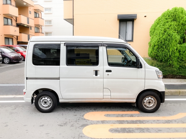 駐車場に停まる白い軽バン
