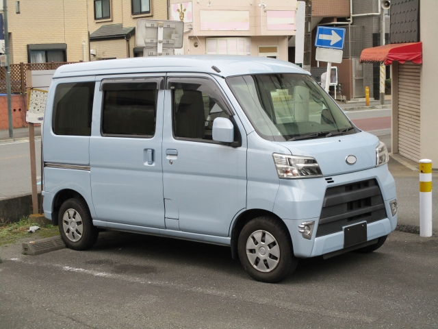駐車場に停まる水色の軽バン