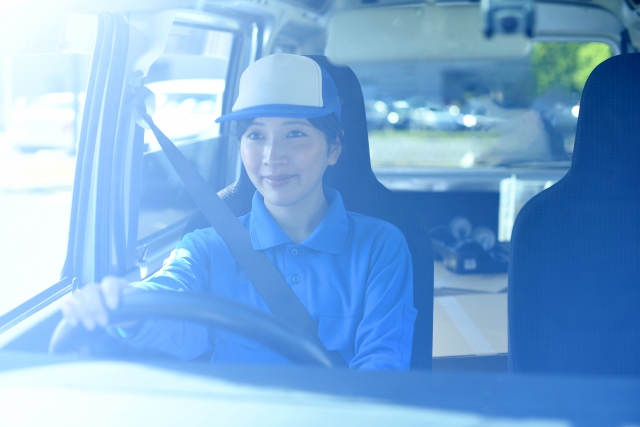 運転席で笑顔を見せる女性ドライバー