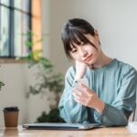 カフェでスマホを使う若いビジネスウーマン